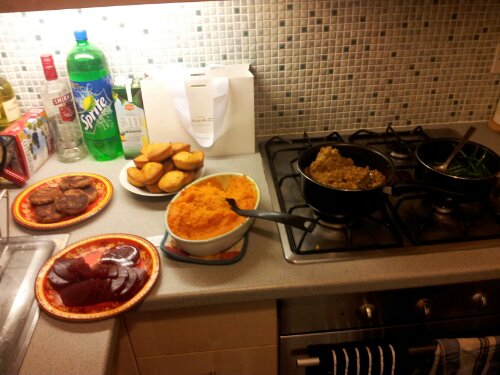 Plates of sweet potato, cranberry sauces, cornbread, vegetarian alternative